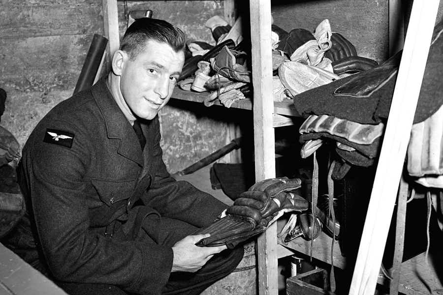 According to the original caption to this photo, taken Feb. 25, 1942: “Aircraftman 2nd Class Milton Schmidt is the only member of the RCAF Flyers hockey team whose duties in the Air Force are similar to his spare time job as a hockey star. The Flyers’ star centre man is becoming a physical training instructor, a job for which he appears admirably fitted.” Photo: DND Archives, PL-6907