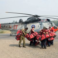 Members of the British Columbia Forest Service pick up their bags after being dropped off by a Sea King in support of OP LENTUS Aug. 21. Photo by Cpl Jeffrey Clement