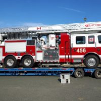 The new Aerial Ladder Fire Fighting Vehicle is unloaded from a transport truck at CFB Esquimalt’s Transport Electrical and Mechanical Engineering (TEME). The new apparatus is one of nine fire trucks being delivered to bases across the country this year. Photo Credit: CFB Esquimalt Fire and Rescue