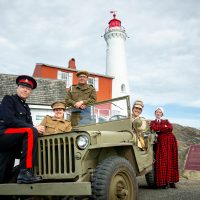 Fort Rodd Hill and Fisgard Lighthouse National Historic Sites interpreters in a 1942 Willys Jeep, in front of Fisgard Lighthouse. Photo by Fritz Mueller, Parks Canada