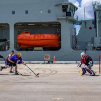 Members of the HMCS Regina and NRU Asterix’s crews play a game of ball hockey during some down time during Operation Projecton on Naval Base Guam in Guam, United States Of America during Operation Projecton on March 7. Photo by Corporal Stuart Evans, Borden Imaging Services