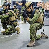 Clearance divers practice an all-around defensive posture with C8 carbine rifles in preparation for a multi-national training exercise with the U.S. Marines in Guam later this month. Photo by Peter Mallett, Lookout