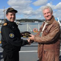 HMCS Calgary Commanding Officer, Cdr Alex Barlow welcomes David McLean aboard for a tour of the warship. Cdr Barlow presented an official captain’s hat and coin to McLean to be given to his 100-year-old father Leslie McLean. McLean sailed aboard the original HMCS Calgary vessel during the Second World War. Photo by Peter Mallett, Lookout