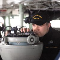 SLt Jason Wychopen takes a bearing from the bridge of HMCS Calgary during Directed Ship Readiness Training.