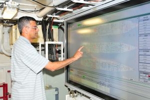 Photo by Shelley Lipke, Lookout Alkarim Nathoo tests new equipment in HMCS Calgary's Machinery Control Room