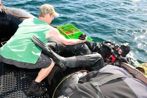 LS Litter helps fellow diver LS Marc Andre Ouimet get into the water for a dive