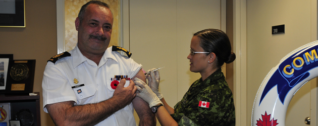 CPO1 Darrel Downey, Acting Formation Chief, receives the flu shot from Primary Care Nurse Lt Laura Brunet.