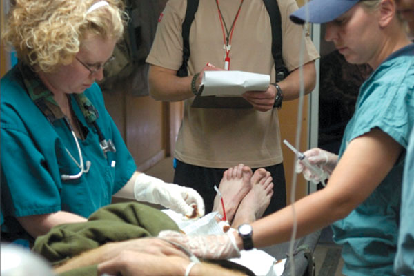 Capt Sandy Robinson works with the medical team on a patient in Afghanistan.