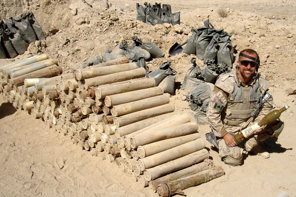 MS Keith Bruce sits next to a stack of ordnance recovered from an Improvised Explosive Device during Op Medusa. 
