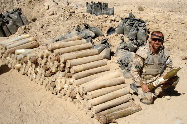 MS Keith Bruce sits next to a stack of ordnance recovered from an Improvised Explosive Device during Op Medusa.