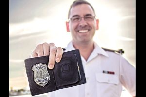 Reservist PO1 LeBlanc shows his Victoria Police Department badge while sporting his military  uniform.