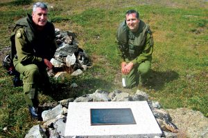 MWO Mike Tuohy (left) and LCol Patrick MacNamara kneel by the Wally Sweetman memorial plaque.