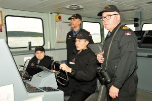="RAdm Bill Truelove watches over two cadets at the helm of, Patrol, Craft ,Training, Vessel, Moose"