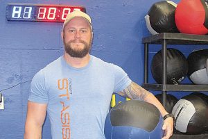 Bruno Guevrémont, owner of CrossFit Stasis, holds a medicine ball – one of the many workout tools used during the varied CrossFit workout.