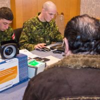 soldiers help refugees apply to Canada