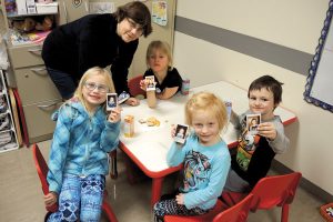 Military Family Resource Centre Instructor Tracy Beck looks on as her students (left) Avery, 7, Jordyn, 5, Sarah, 6, and Conrad, 5, hold up pictures of themselves during a deployment workshop at the Colwood Pacific Activity Centre.