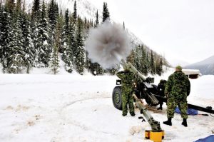 A Roto 2 member takes a sight of the avalanche zones on Rogers Pass on one of the  105-mm C3 howitzers located at a road-side gun platform.