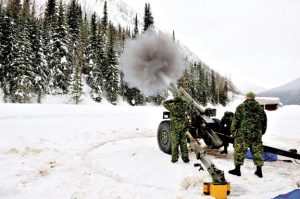A Roto 2 member takes a sight of the avalanche zones on Rogers Pass on one of the 105-mm C3 howitzers located at a road-side gun platform.