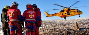 Members from Iceland Association for Search and Rescue (red suits) and a Coast Guard member wait for the CH-149 Cormorant helicopter from 103 Squadron Gander during a Joint SAR Exercise held in Iceland on Feb. 10. 