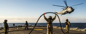 Members of HMCS FREDERICTON Air Detachment, perform a mid air refueling with the CH-124 Sea King helicopter from the flight deck during Operation Reassurance on Jan. 21.