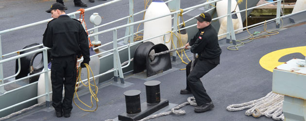 sailors work forward lines during departure