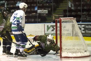 LS Ogle Henry, MARPAC Imaging Services CAF Warriors goaltender CP02 Ken Simoneau makes a save as Canucks Alumni forward Dave ’Tiger’ Williams looks for a rebound during Heroes Hockey 2016 action at the Q Centre on March 6.