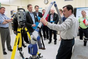 Dan Ouellette, group leader of Quality Engineering Test  Establishment, Measurement Sciences in Ottawa, demonstrates the movement of an articulating arm Coordinate Measurement Machine, which is used for both contact (tactile probing/scanning with a stylus), and non-contact scanning using a laser accessory at the recent Open House.