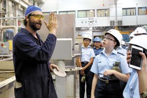 Apprentice Dustin Ross explains to the cadets about precision cutting of metal.