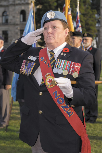 Terri Orser, a member of the Royal Canadian Legion, salutes during the playing of the Last Post.
