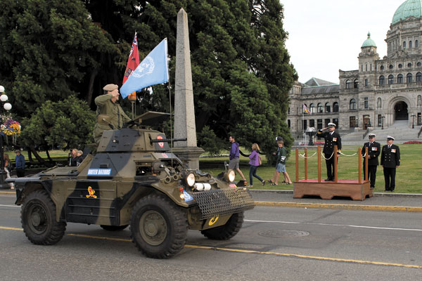 A Ferret Armoured Car from the Ashton Garrison Military Museum drives by the reviewing stand as Reviewing Officer Cdr Jeff Watkins salutes. Photos by LS Ogle Henry, MARPAC Imaging Services