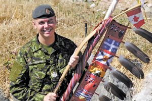 Sgt Moogly Tetrault-Hamel brings the Canadian Armed Forces Eagle Staff ashore during a ceremony on Esquimalt Nations territory, Aug. 19, 2015. Photo by Peter Mallett, Lookout