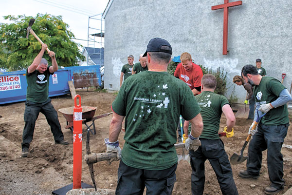 HeroWork volunteers swing their pick axe and shovels while performing landcaping work as part of their Radical Renovation of the Rainbow Kitchen on the grounds of the Esquimalt United Church. Photo by Tom Gore, HeroWork