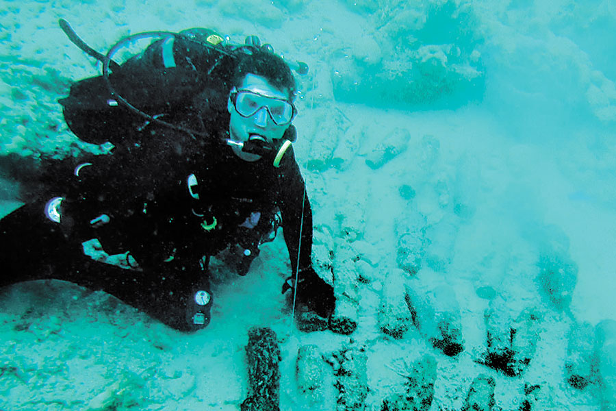 Royal Canadian Navy sailor Leading Seaman Josh Adams, of Fleet Diving Unit Pacific, prepares to dispose of unexploded projectiles found underwater near White Beach in the Solomon Islands during Operation Render Safe.