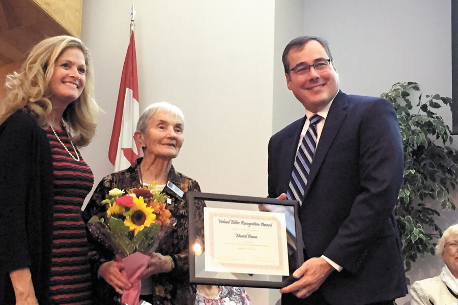 MFRC volunteer Muriel Dunn receives the Valued Elder Recognition Award from (left) Lorie McLeod, Executive Director of the Greater Victoria Eldercare Foundation, and Scott Hofer, University of Victoria Director of the Institute on Aging and Lifelong Health, at the Salvation Army Citadel. Photo credit University of Victoria