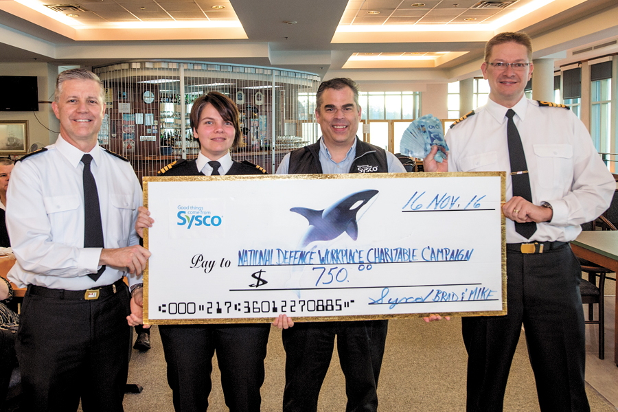 Brad Gable (center right), the Director of Contract Sales for Sysco, presents a cheque for $750 to the Commander of MARPAC/JTF (P), Rear Admiral Art McDonald (left), Base Administrative Officer Commander Jeanne Lessard (center left), and Base Commander Captain (Navy) Steven Waddell (right), during the National Defence Workplace Charitable Campaign fundraising Pancake Breakfast at the Chief’s & Petty Officers’ Mess, Nov. 16. Photos by MCpl Brent Kenny, MARPAC Imaging Services