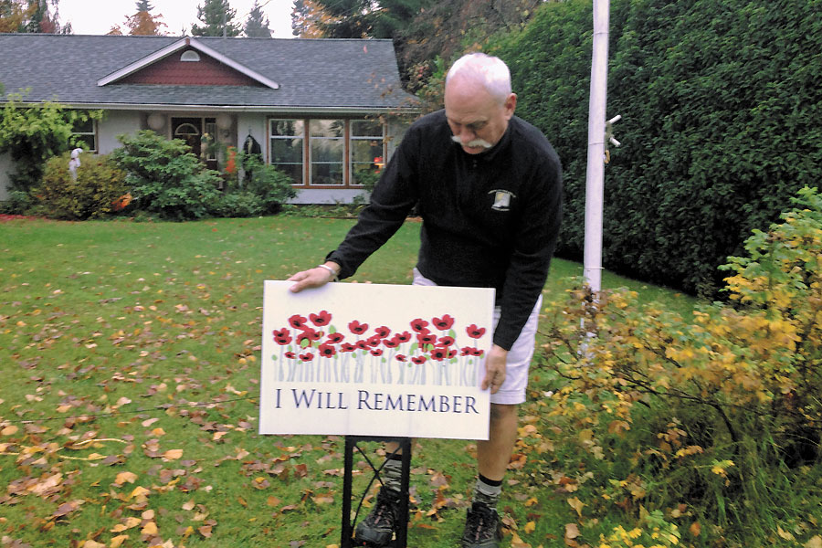Salsbury House B&B owner James Derry places a ‘I will Remember’ sign on his lawn. Credit Lewis Batholomew/Alberni Project