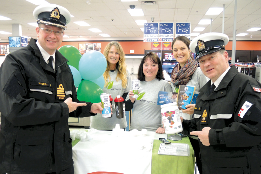 Capt(N) Steve Waddell and CPO1 Gino Spinelli joined CANEX staff Tracy Horner and Sara Johnson, and Health Promotion’s Allie Jones in handing out healthy food choices to patrons of Naden’s CANEX outlet Jan. 11. The food items are now labelled with “Benefit” identifiers as part of a new healthy food program at the retail store. Photo: Peter Mallett, Lookout Newspaper