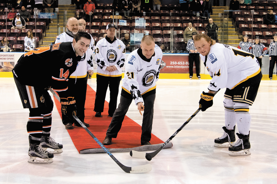 Team captains Cole Pickup of the Victoria Grizzlies (right), and Spencer Hawson of the Nanaimo Clippers get set for the ceremonial puck drop by PO2 Allan Kobayashi, Wounded Warriors Canada, at the Q Centre Arena in Colwood, Jan. 12. The BCHL team has designated the month of January Wounded Warrior month and is auctioning off specially-designed team jerseys on behalf of the non-profit and its upcoming Wounded Warrior Run. Photo by Kyle Robinson Photography