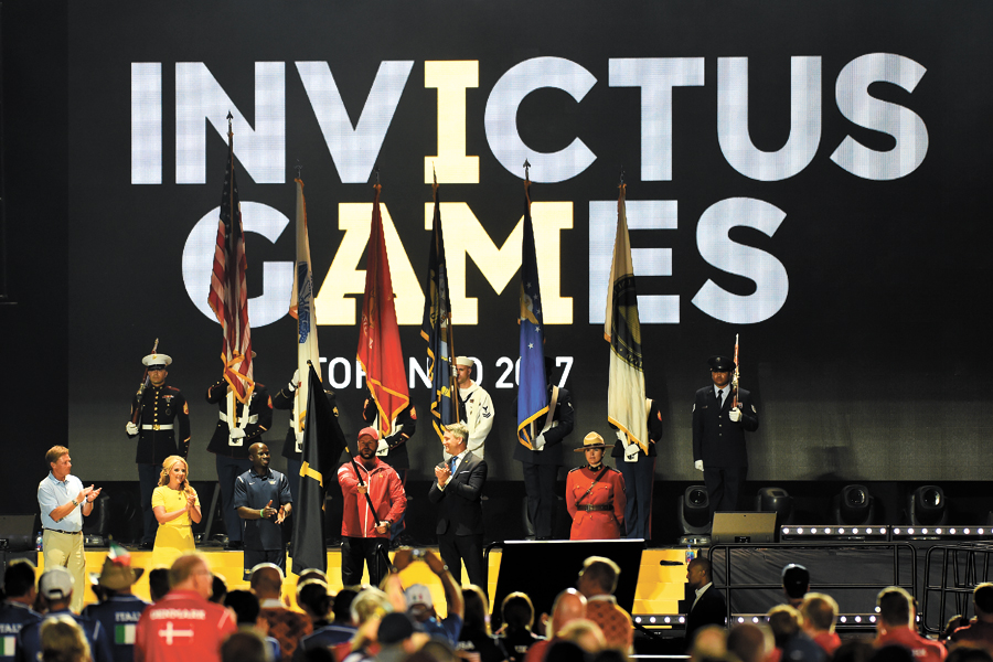Team Canada captain Bruno Guevremont (centre) holds the Invictus Games flag at the conclusion of the 2016 Invictus Games in Orlando, Fla. The flag was passed to Guevremont to introduce the 2017 Invictus Games, which will be held in Toronto in September.