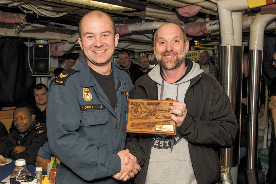 LS Matt Corbett, a hull technician in Athabaskan, was presented the plaque from the ship’s Junior Rank Mess by CPO1 Fred McCrea, who came back to his former ship for the final day sail on Feb. 8. Photo by Cpl Tony Chand, FIS Halifax