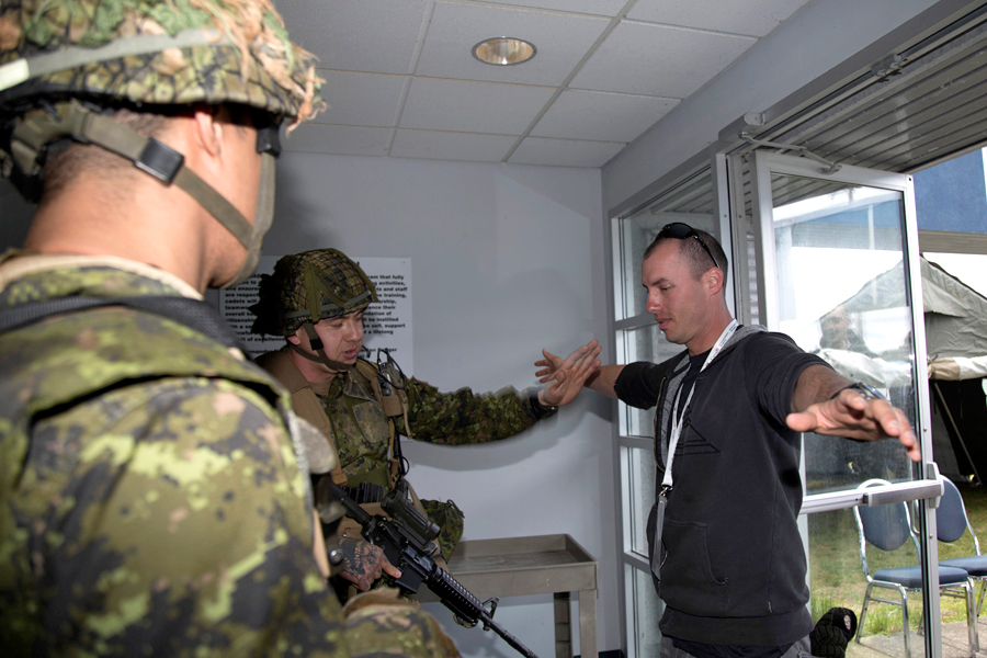 A soldier from the 3rd Battalion, Princess Patricia’s Canadian Light Infantry (PPCLI), conducts a security check on a “Canadian citizen” entering the processing centre. Photo by Capt Elizabeth Tremblay-Lewicki, 2 Wing Public Affairs