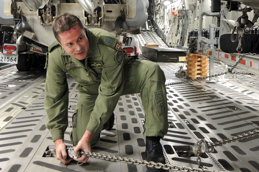  MWO Dave Daly, a Loadmaster with 429 Transport Squadron in Trenton, Ont., secures a RHIB to the floor of a C-17 Globemaster cargo plane. Photo by Peter Mallett/Lookout