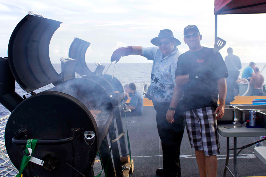 Crewmembers enjoy a barbeque on the flight deck, served up by the Chiefs and Petty Officers.