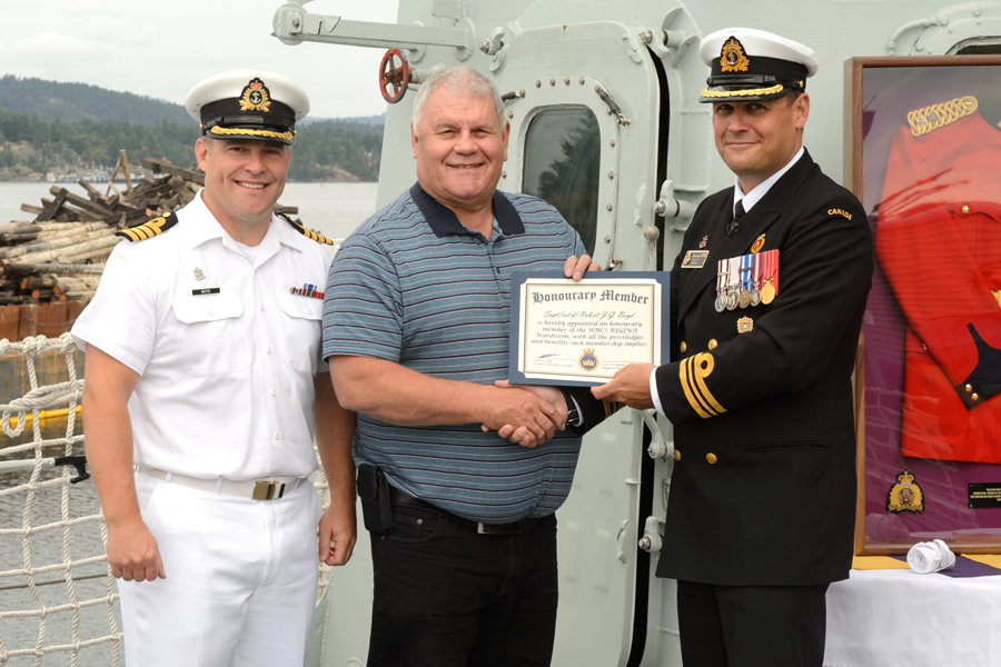 Royal Canadian Mounted Police Superintendent (Retired) Robert Boyd receives an honorary membership to HMCS Regina’s wardroom by the ship’s Executive Officer, Lieutenant-Commander Andrew Graham and Base Commander, Captain (Navy) Jason Boyd.