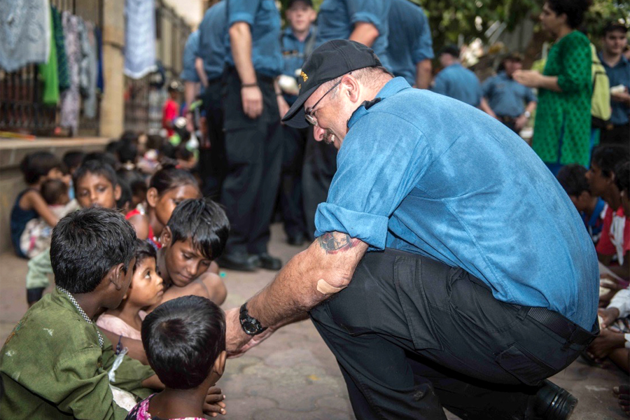 LS Craig Langille chats with children in Mumbai, India. Photo by Padre Lt(N) Matthew Squires