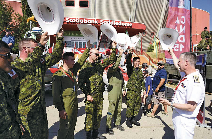 Military members wave their white cowboy hats with Rear-Admiral Art McDonald at the Calgary Stampede. Photo by Ashley Materi, 3rd Canadian Division Public Affairs