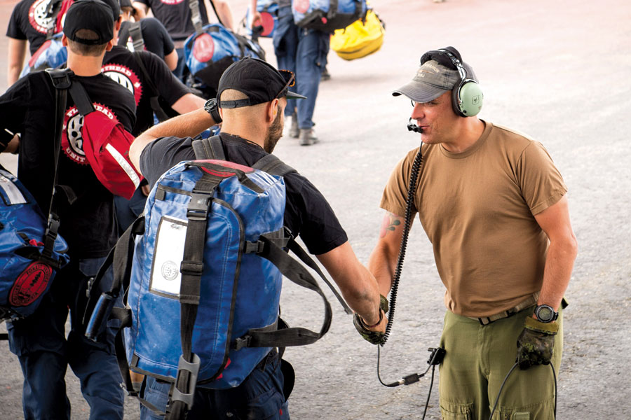 A member of the Ministry of Forests Flathead Unit Crew is greeted by Sergeant Neil Maclean at Puntzi Mountain Airport. Photo by MS Roxanne Wood, 19 Wing Imaging