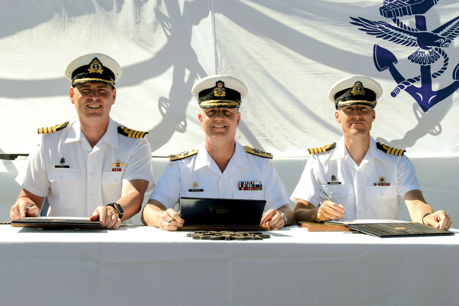 From left to right: Outgoing Commanding Officer, Captain (Navy) Christopher Earl; Commander Maritime Forces Pacific, Rear Admiral Art McDonald; and Incoming Commanding Officer, Captain (Navy) Ed Hooper sign transfer of command certificates. Photo by Cpl Blaine Sewell, MARPAC Imaging Services