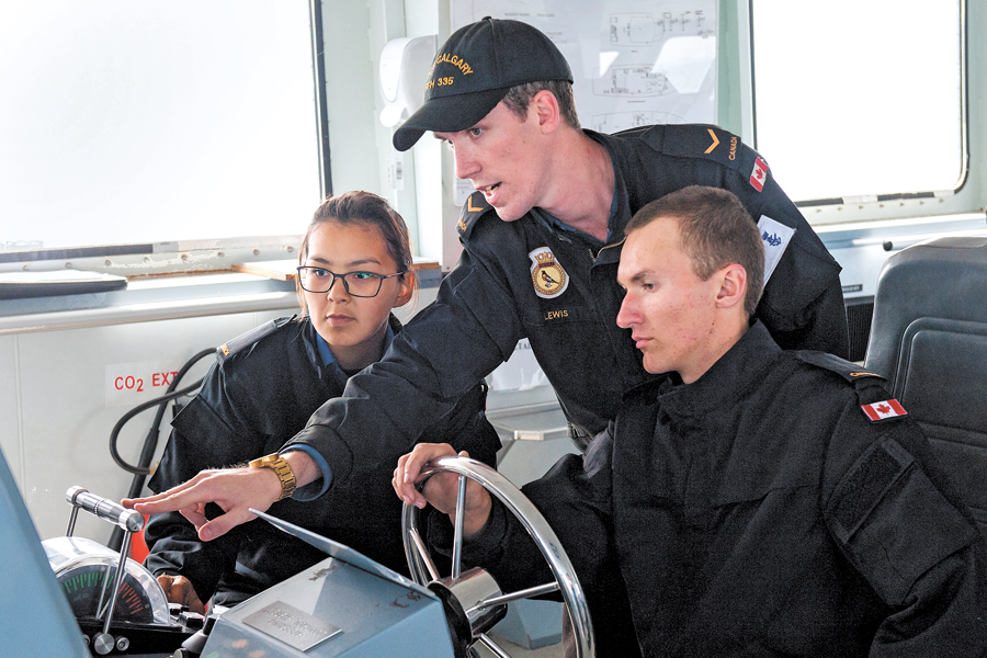Two candidates for the Raven Program, OS Nicole Kununak (left) and OS Sam Seven Deers (right), receive maneuvering instructions from AB Nathaniel Lewis, during the day sail on Aug. 14. Photo by LS David Gariepy, MARPAC Imaging Services