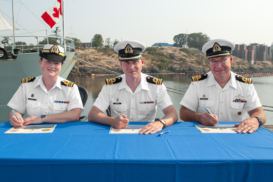Reviewing Officer, LCdr Lucas Kenward (centre), signs the certificate officiating the command change between Outgoing Commanding Officer, LCdr Todd J. Bacon (right), and the Incoming Commanding Officer, LCdr Kristina Gray (left). Photos by LS David Gariepy, MARPAC Imaging Services